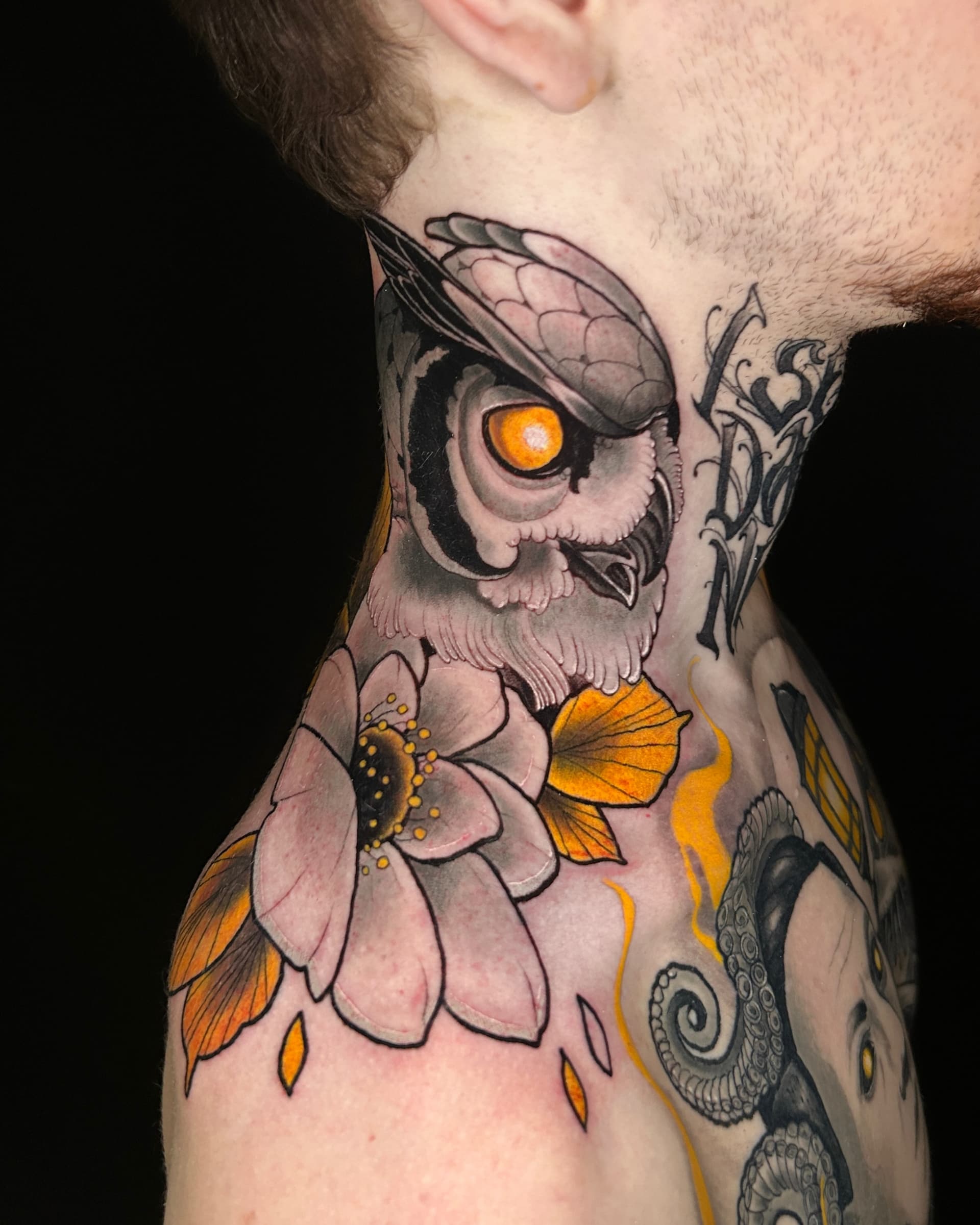 Neo traditional tattoo of an owl with a glowing orange eye and a flower — bold illustrative color design