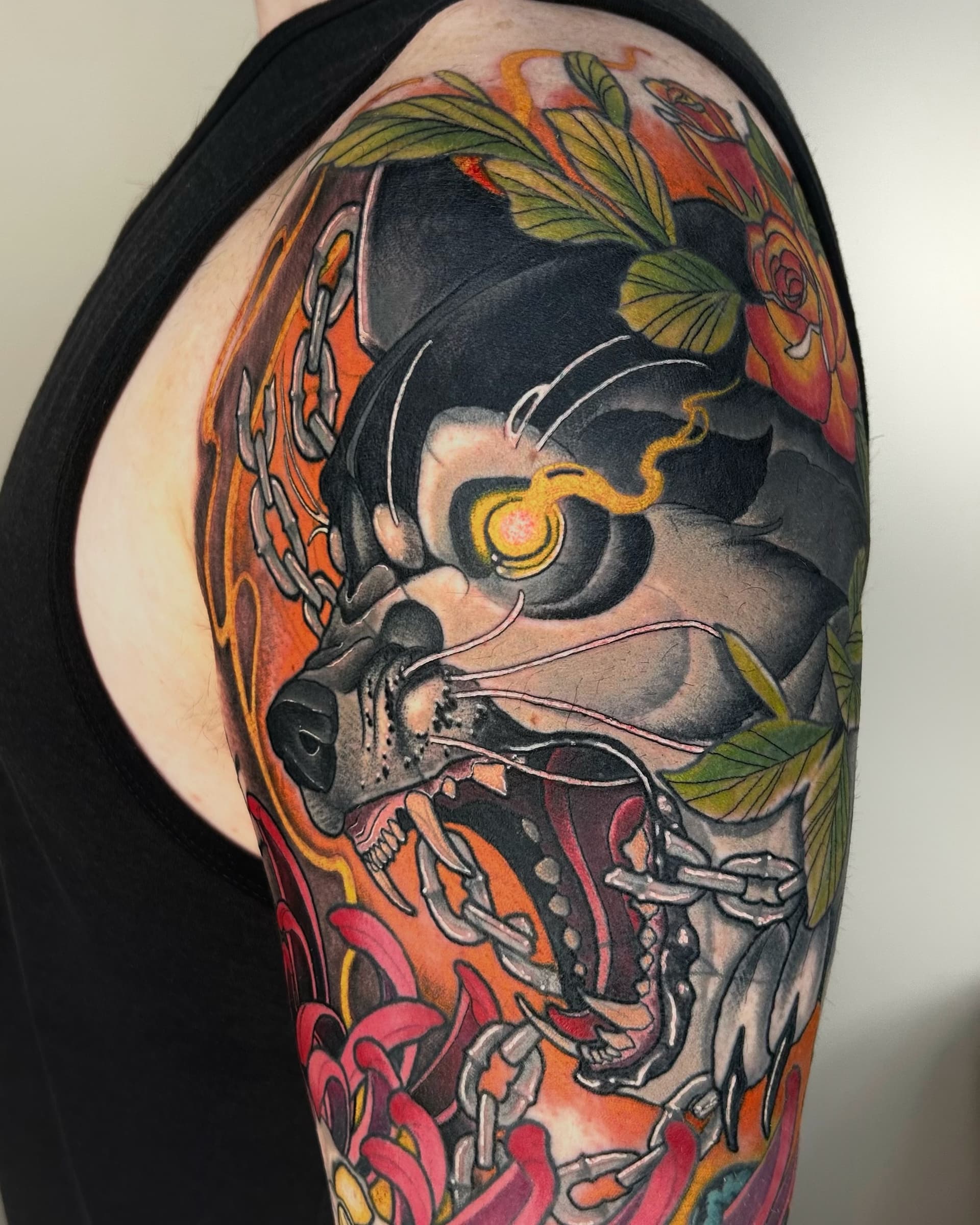 Neo traditional wolf tattoo with chains and flowers on upper arm — vibrant color design