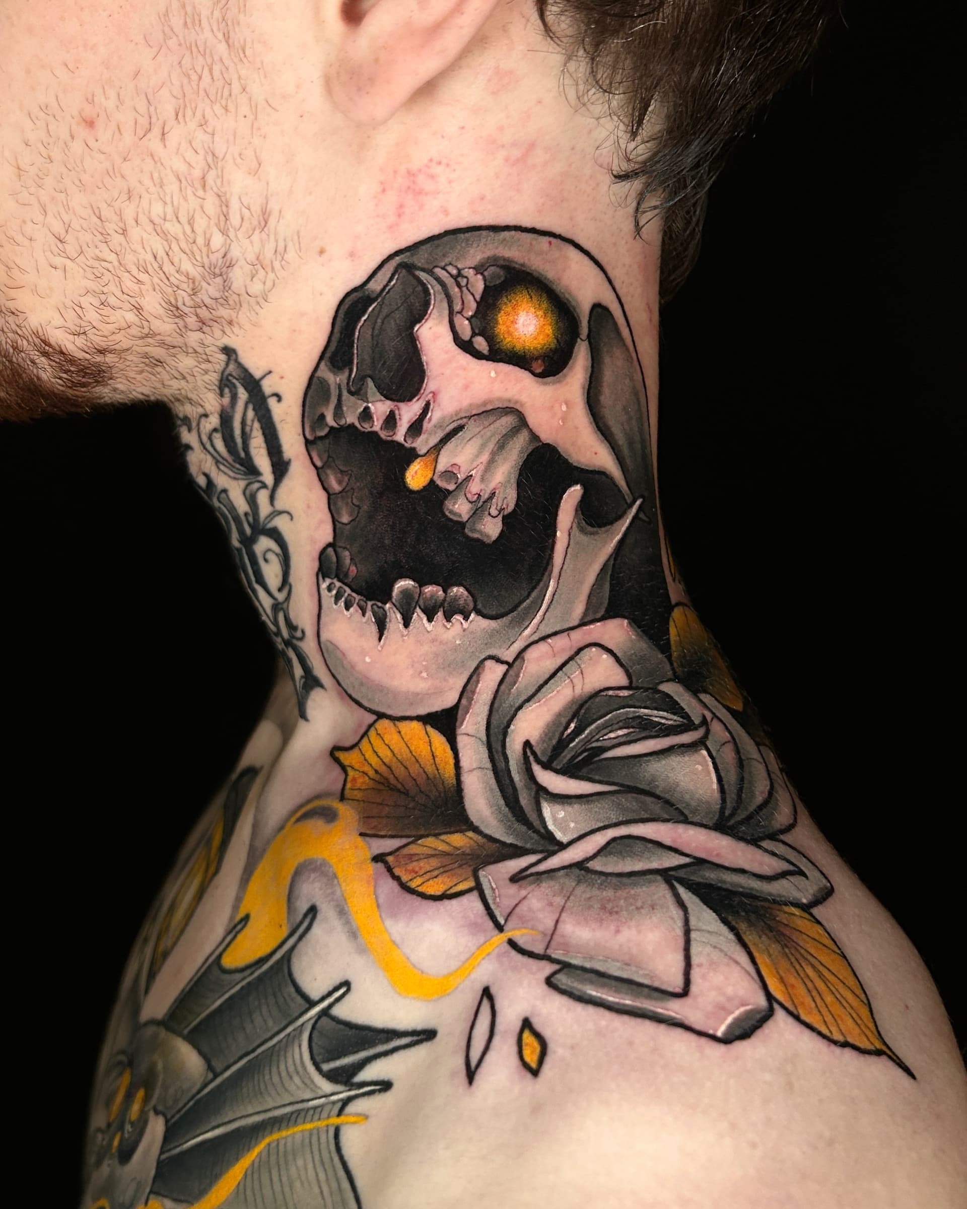 Neo traditional tattoo of a skull with glowing golden eyes and a rose — bold illustrative color design