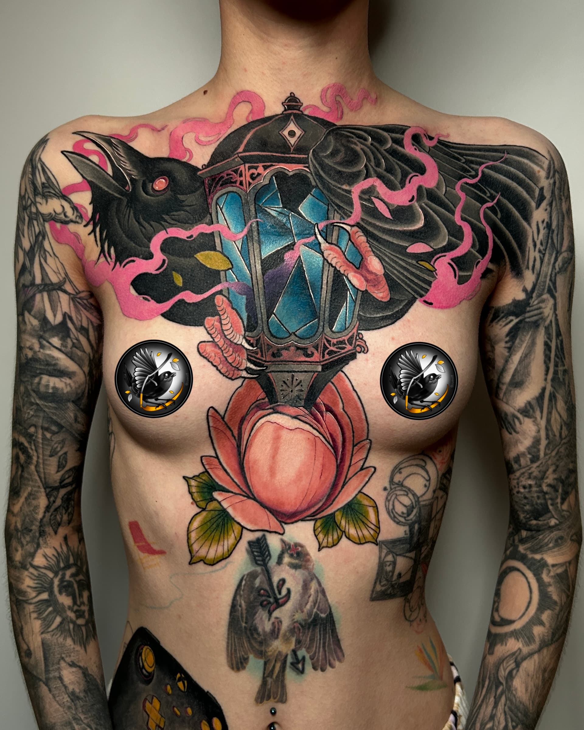 Neo traditional chest tattoo of a raven around a glowing lantern with pink smoke — bold illustrative color design