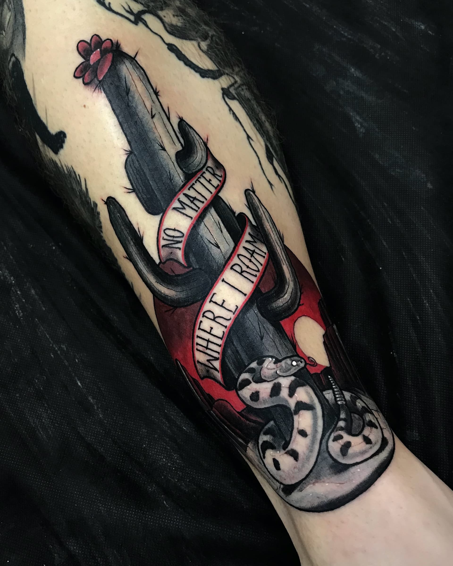 Neo traditional tattoo of a cactus with a snake and red banner — bold Wild West-inspired color design